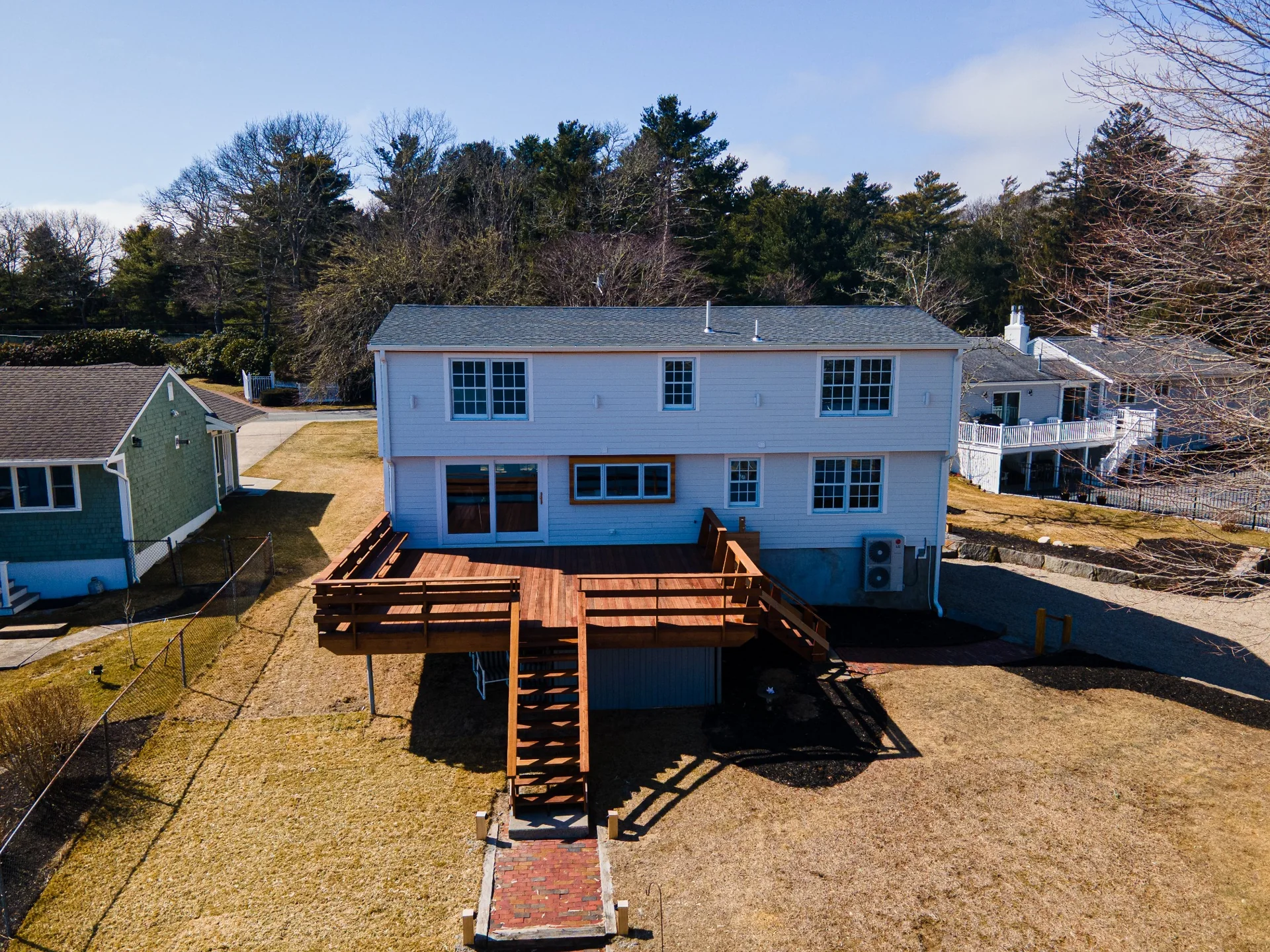 Aerial view of a custom rear deck, stairs, railing, and waterfront backyard exterior craftsmanship.